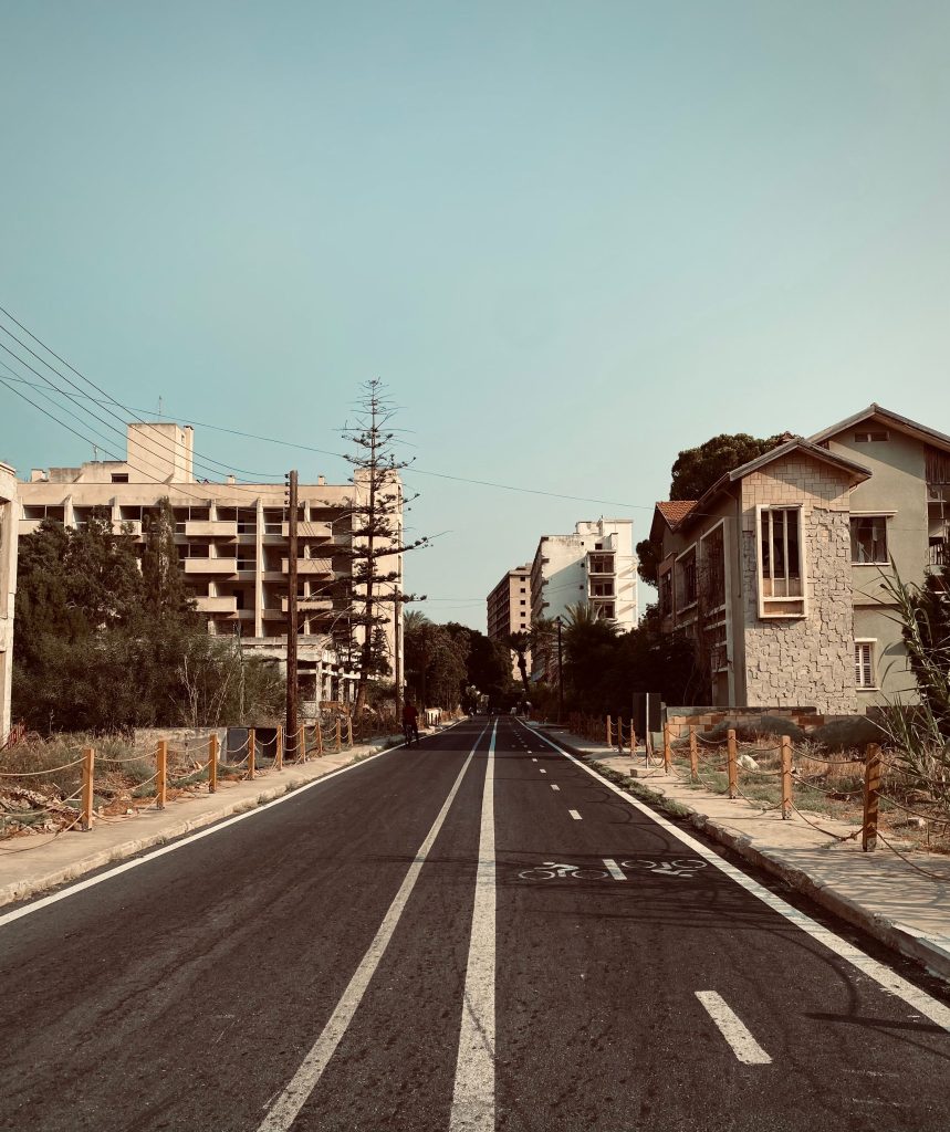 A serene view of an empty street lined with buildings in Famagusta, showcasing urban architecture and a bicycle path.